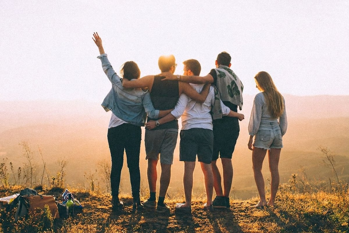The same hilltop with the woman now standing to the right of the group, her shadow falling with theirs
