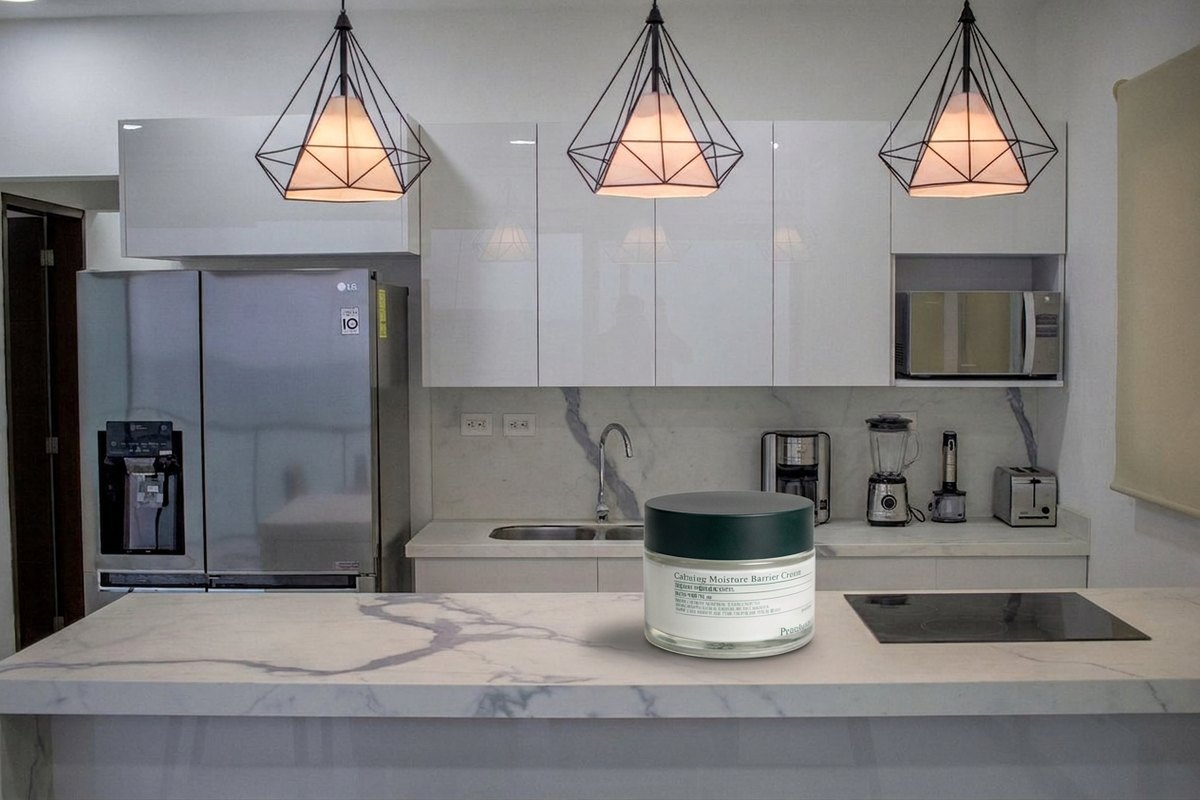 The same kitchen with the jar standing closed on the marble island beside the hob