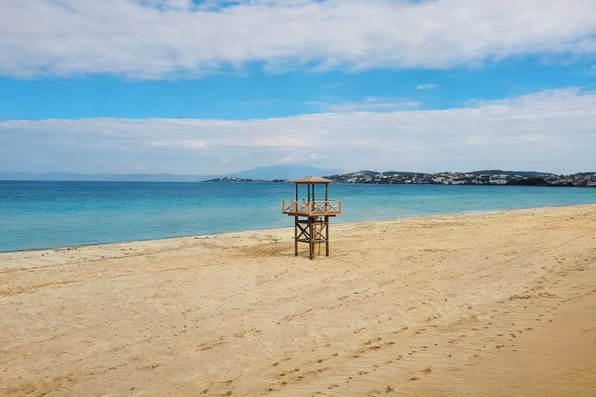 The same beach as a wide banner, the tower unchanged and the sand continued outward