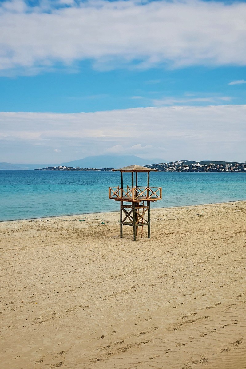 A vertical photo of a wooden lifeguard tower on an empty beach