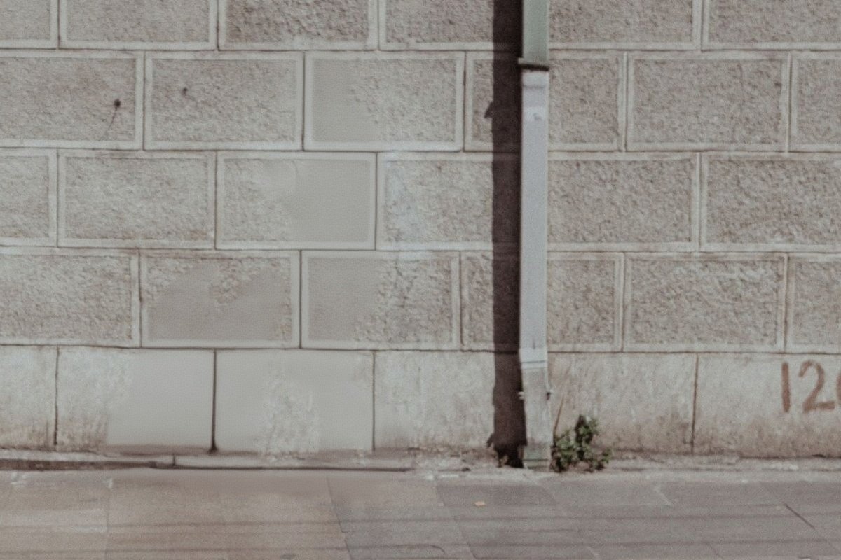 The same wall and pavement, with the man and the shadow both gone